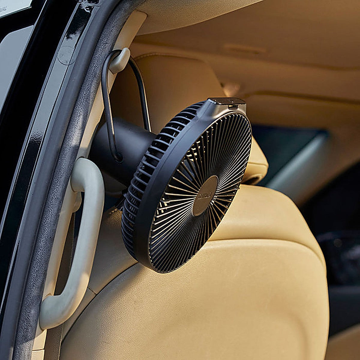 Black V1040 fan hooked on a car headrest for interior cooling