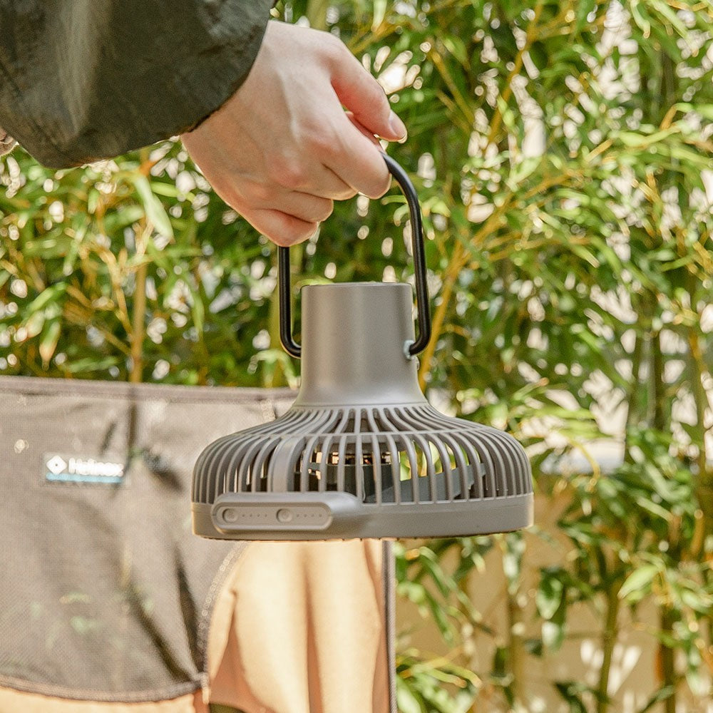 Hand carrying the V600+ fan by its wire handle outdoors