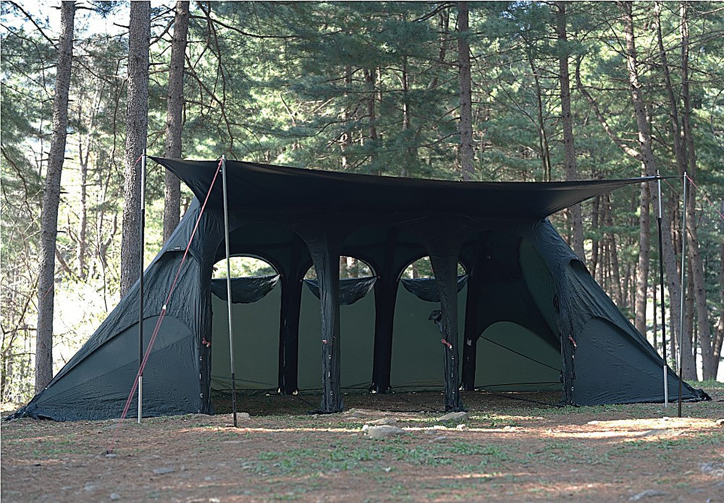 Front view of the black-coated Gopamir side tarp forming a wide canopy over the tent's arched mesh openings