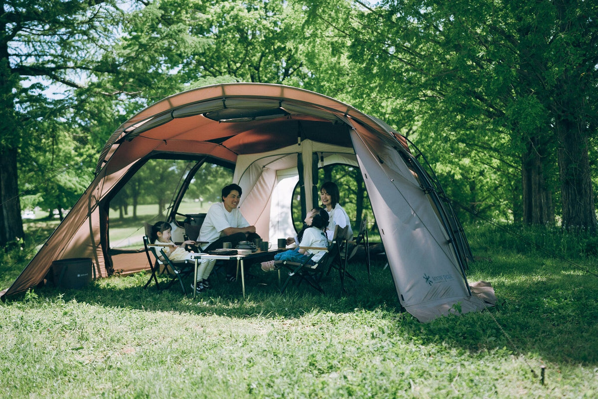 Land Lock X, Brown, a family of four seated inside at a woodland campsite