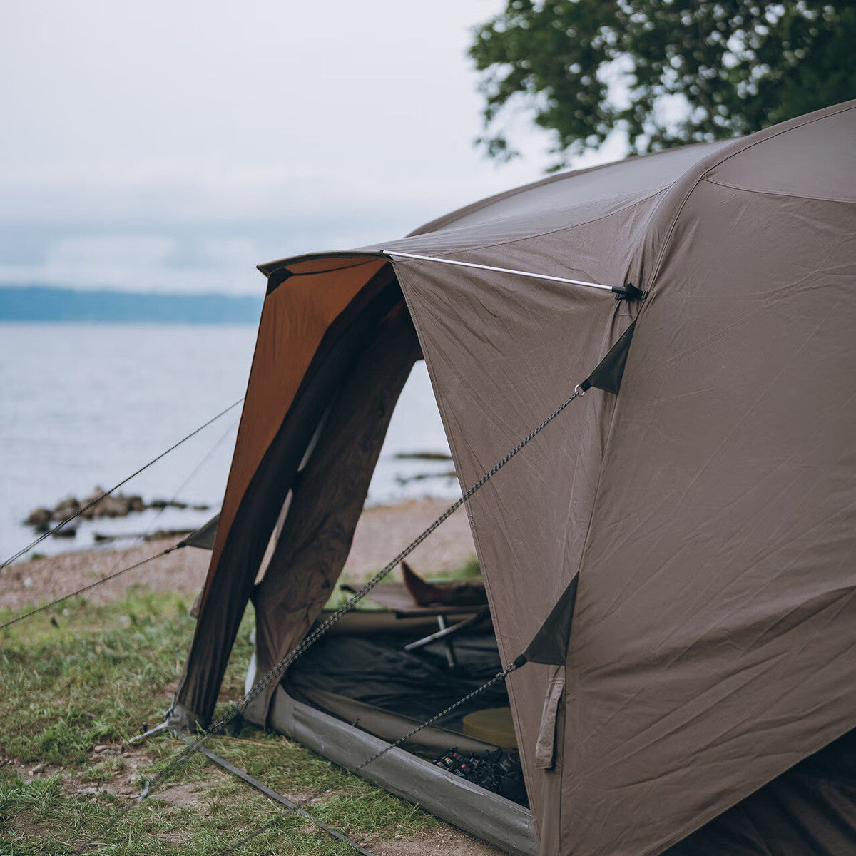Aero Cumulus Shell, Brown, pitched beside a lake