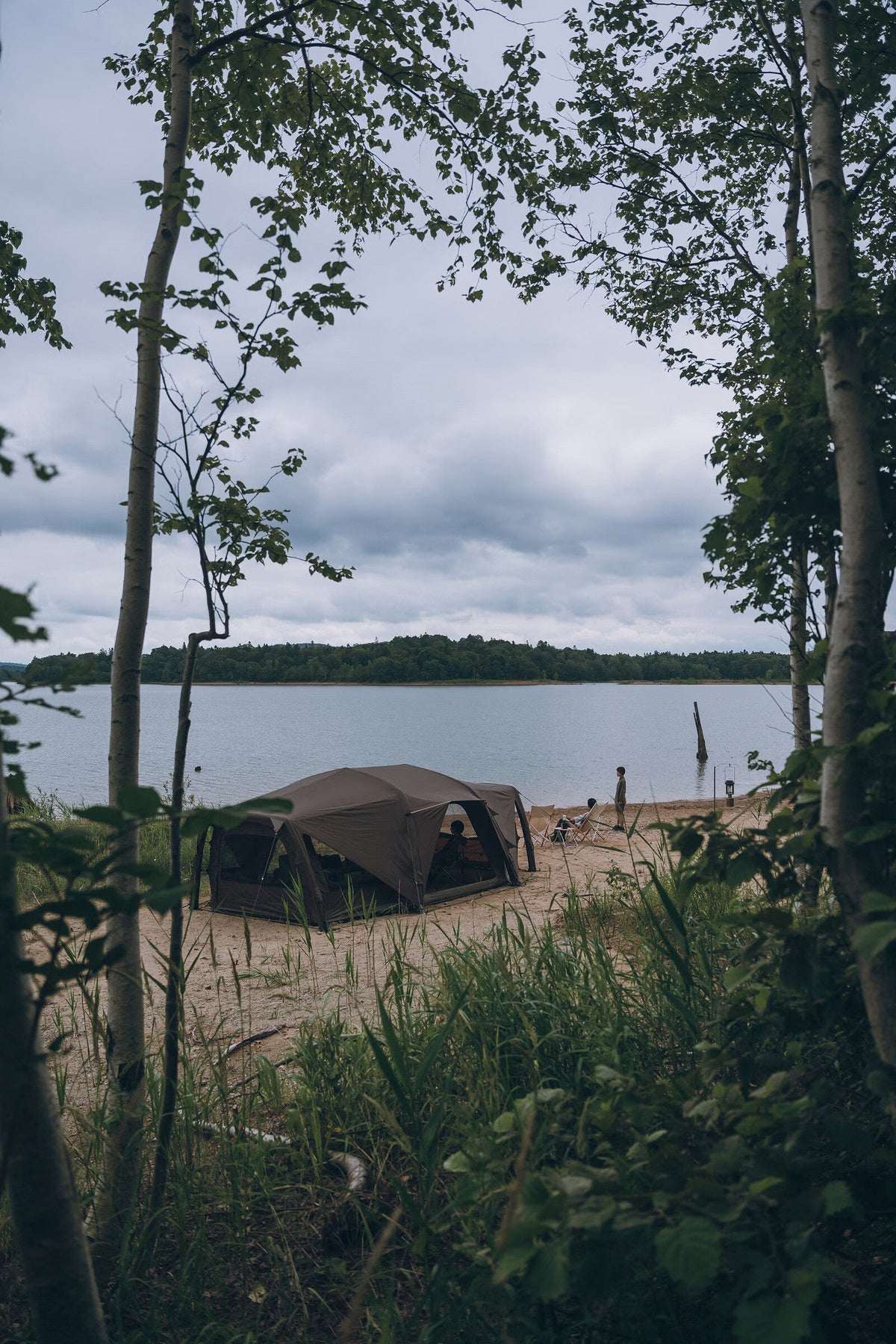Aero Cumulus Shell, Brown, wide view of the shelter at a lakeside campsite