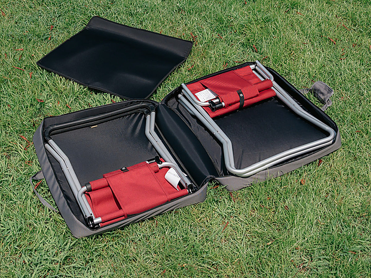 CORDURA FD Chair Case open on grass with two folded red FD Chairs inside and the centre partition set aside