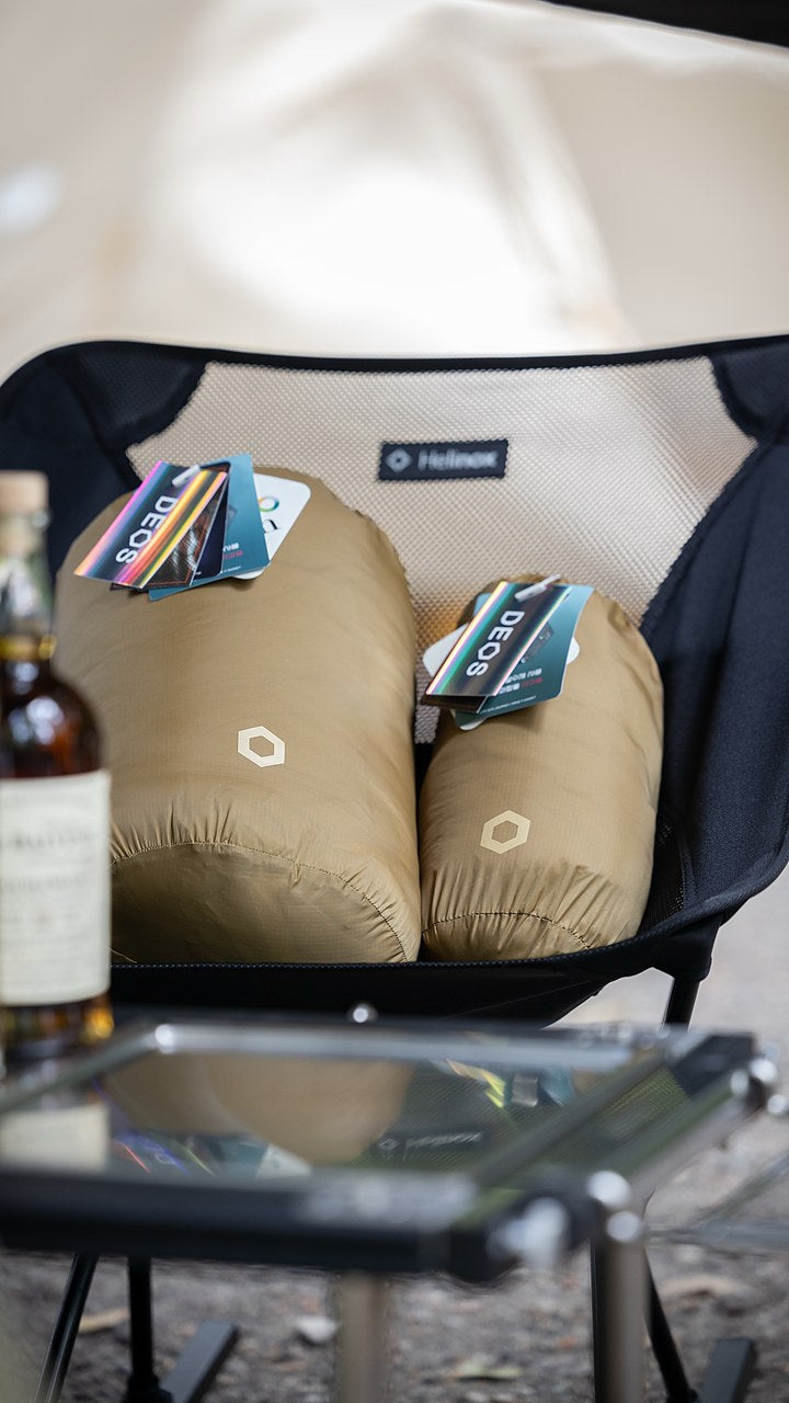 Field-tester photo — two DEOS pieces in stuff sacks resting on a camp chair