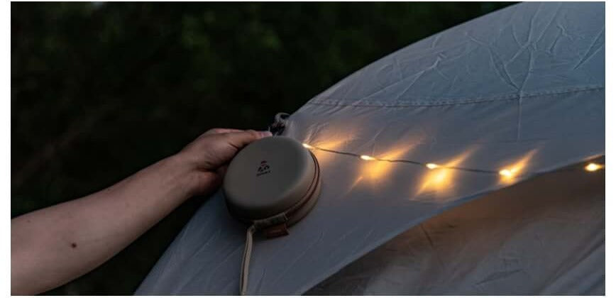 Hand attaching the lantern to a metal surface using its built-in magnets
