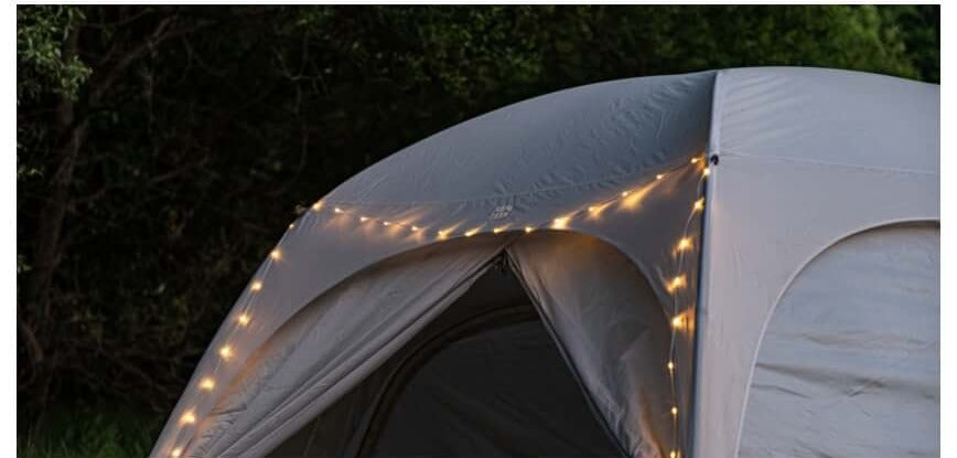 Warm string light wrapped around a tent's seams at night