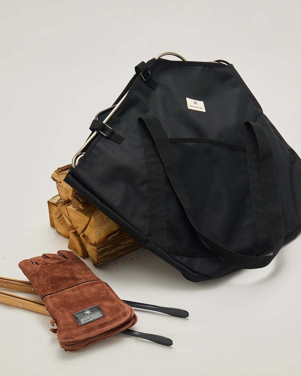 Fireplace Bag L beside leather gloves and a base plate