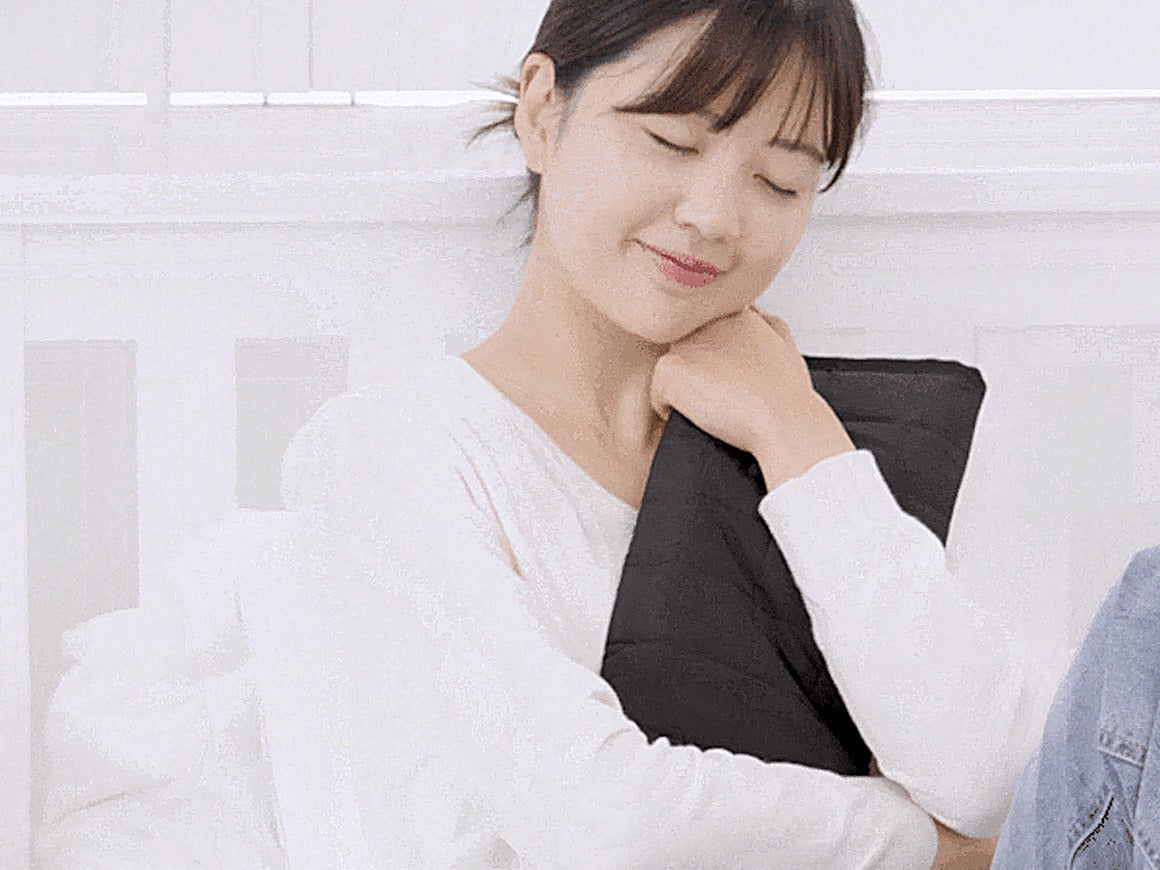 Woman hugging the Carbon Heating Pad Small close to her body