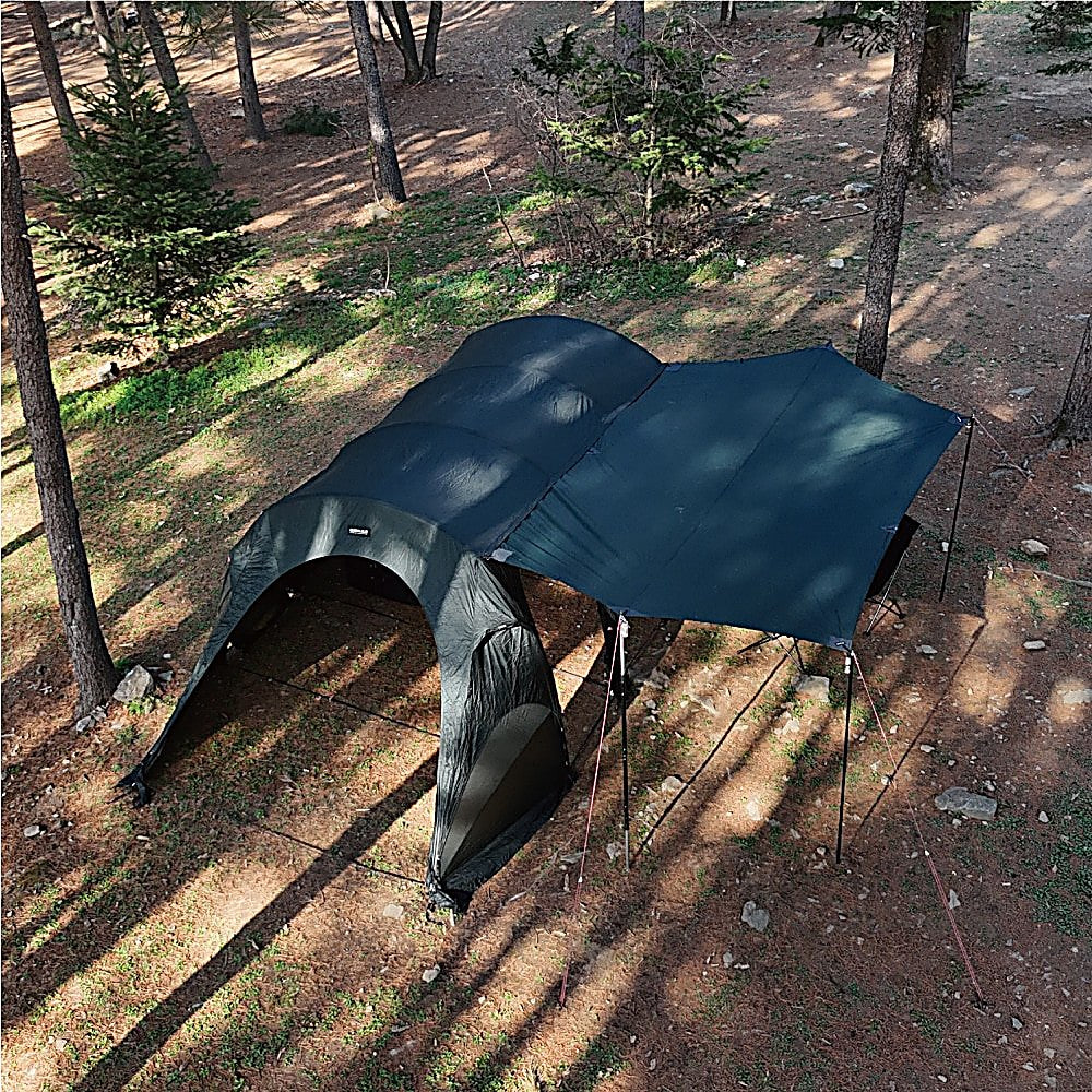 High-angle view of the T720+ Side Tarp panel joined to the dome tent roof, guylines staked in a clearing