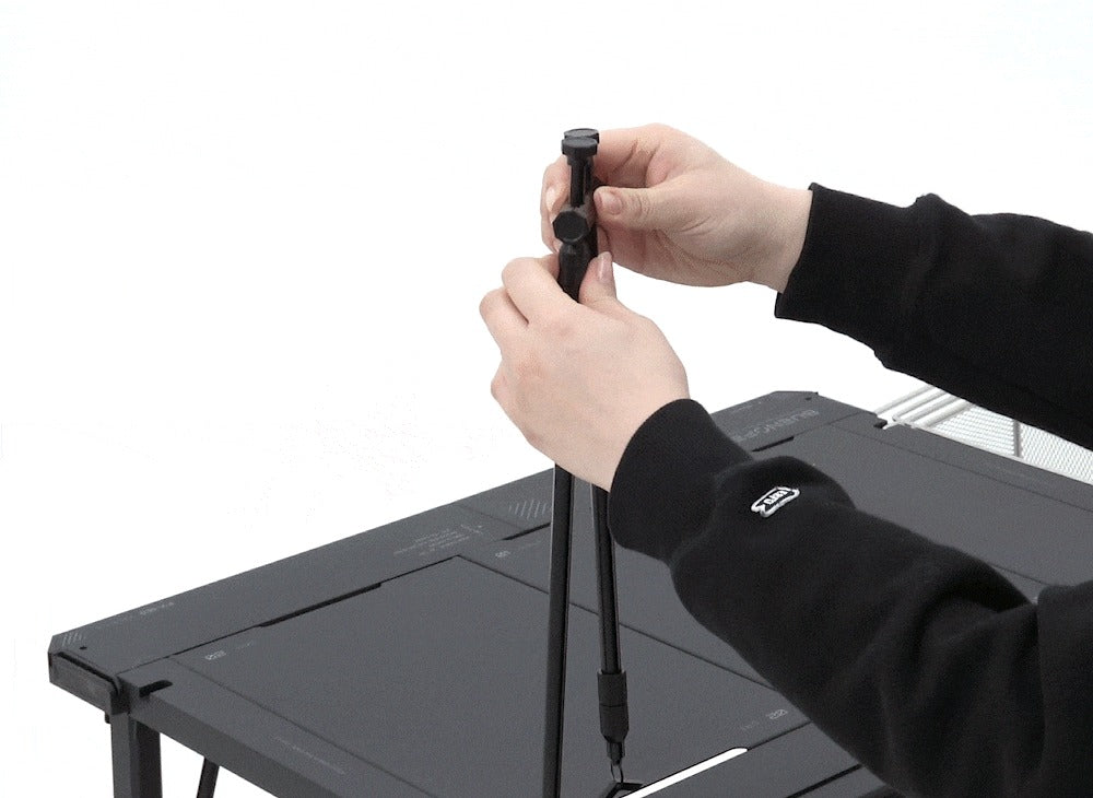 BUENOFE IGT Lantern Hanger installation step 1: hands mount the base pole onto a black IGT table and tighten the clamp knob to fix it in place.