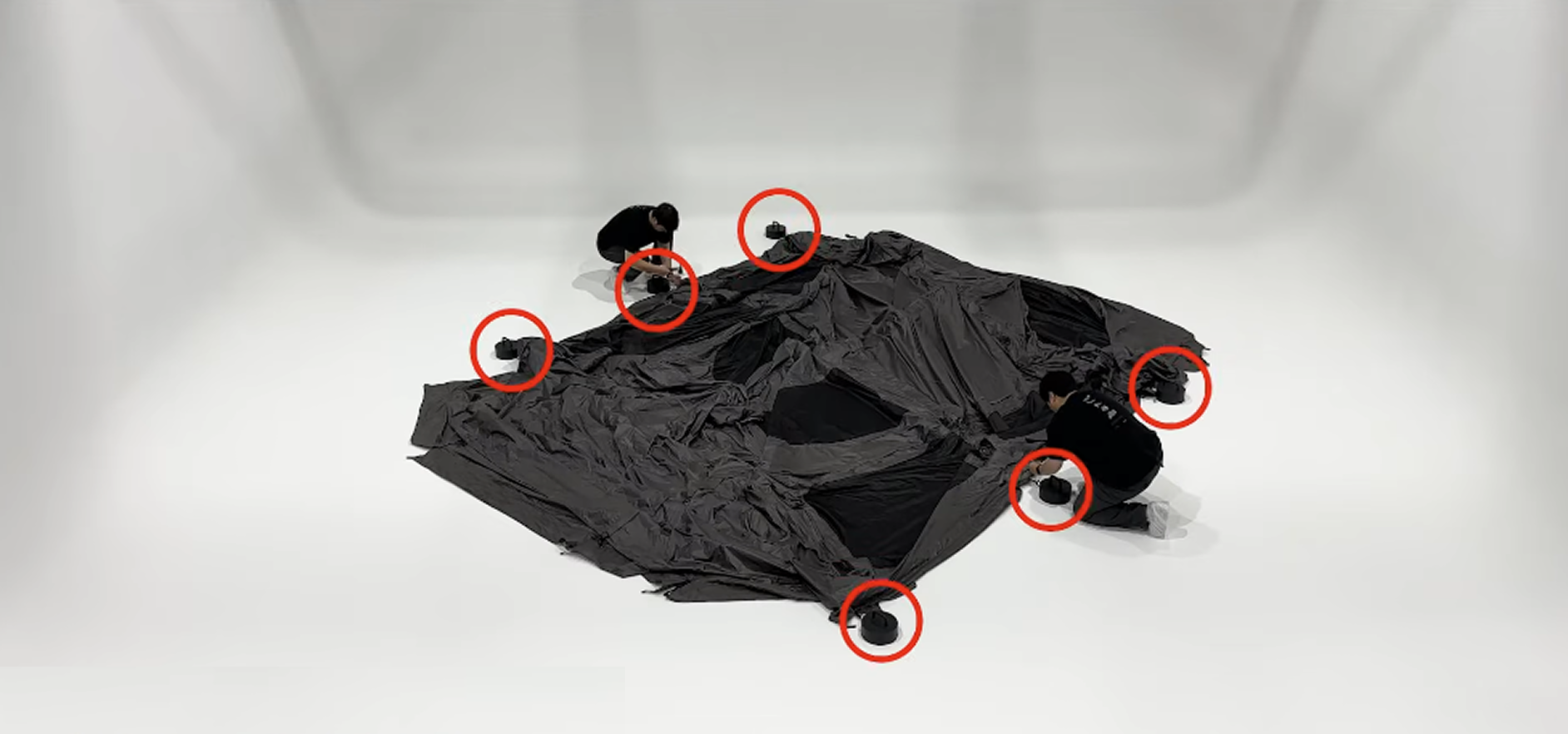 Albion air tent laid flat with the four corner stake points circled