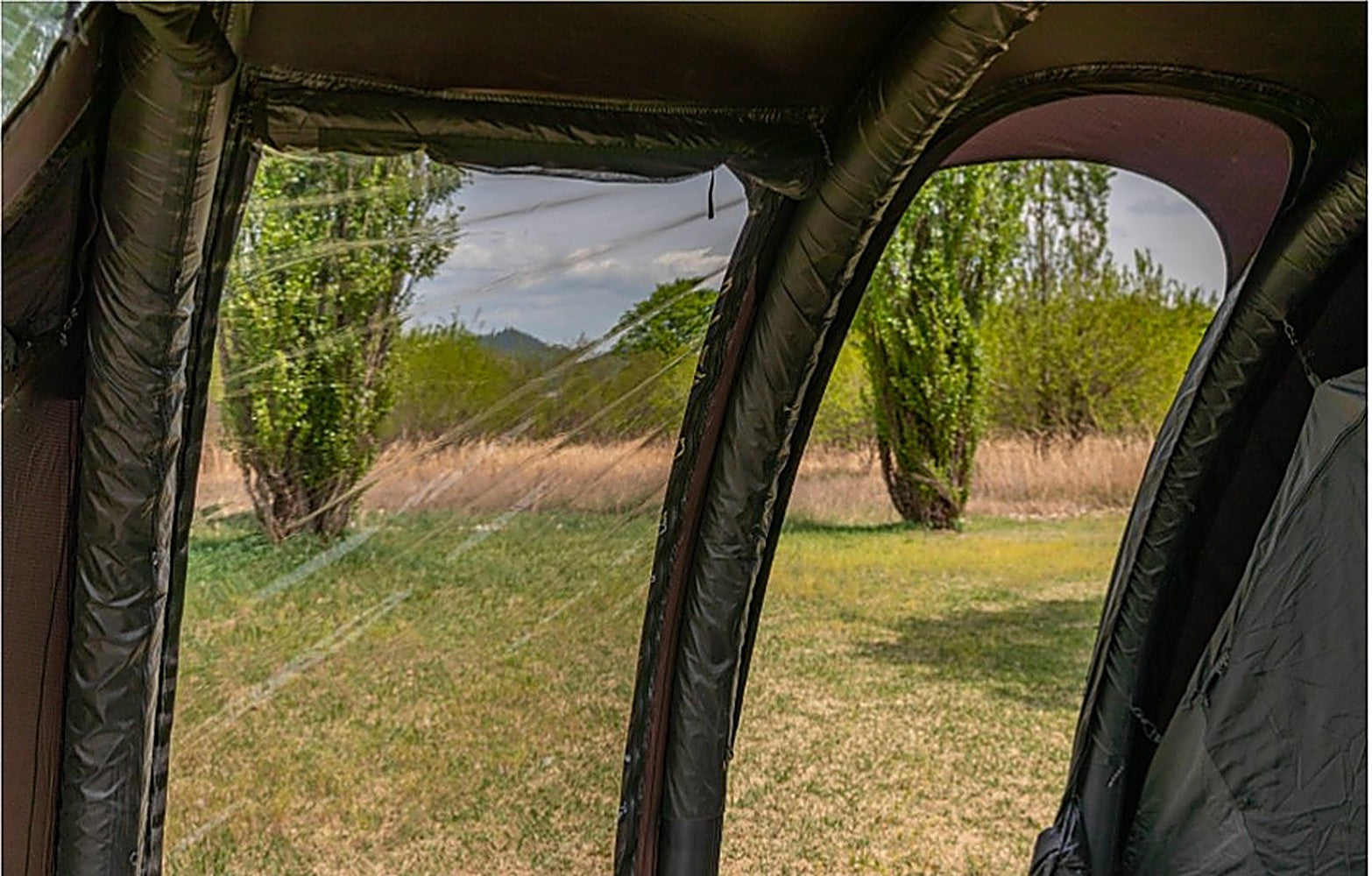 Interior view through the Ghost Phantom Air TPU side extension's clear panel onto a grassy meadow and trees