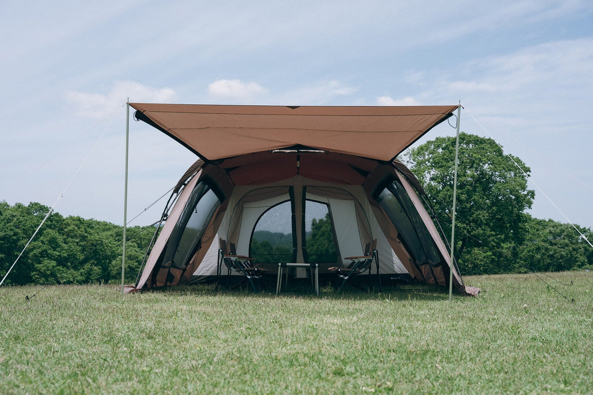 Land Lock X, Brown, front elevation with the awning extended on an open meadow