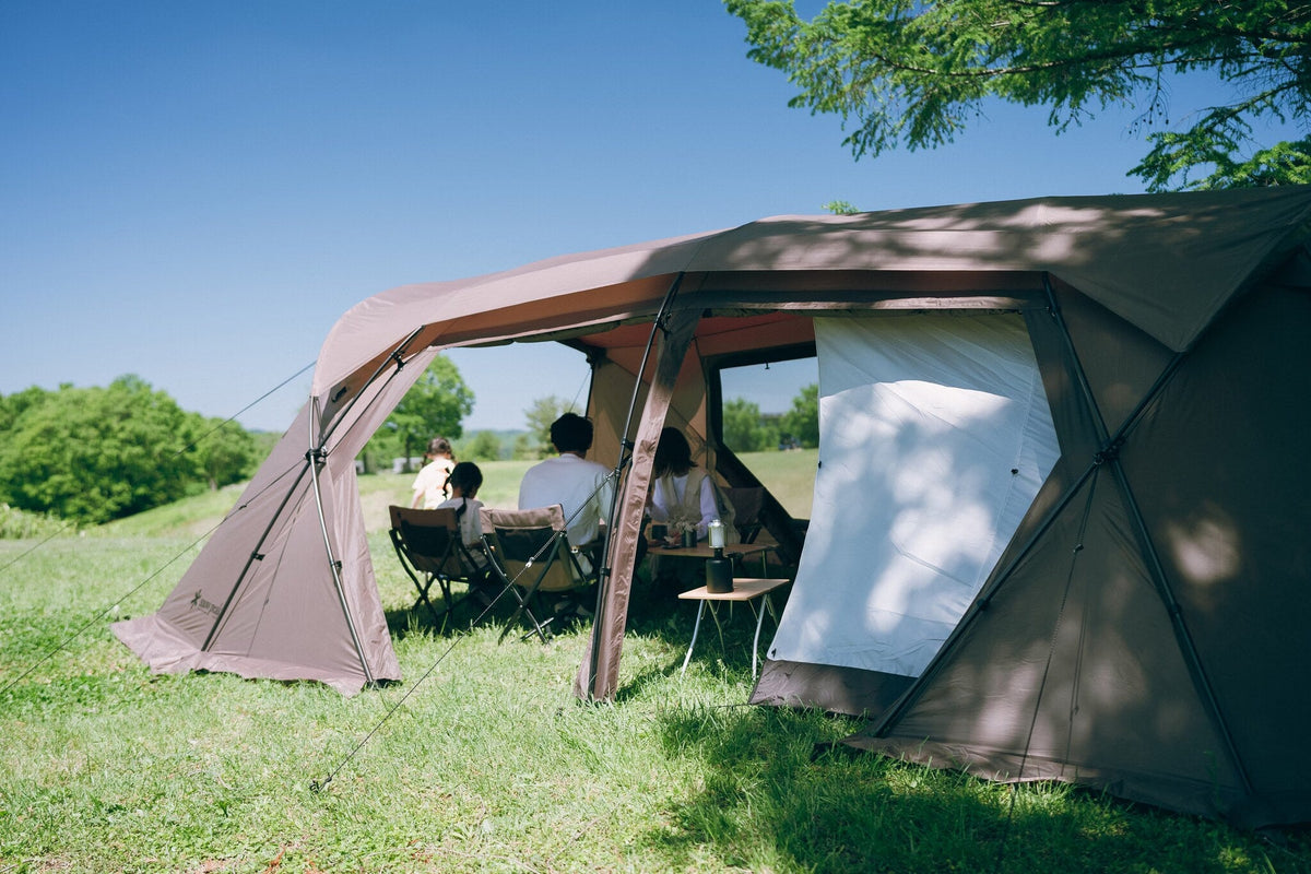 Land Lock X, Brown, side view with the awning out and a group seated inside