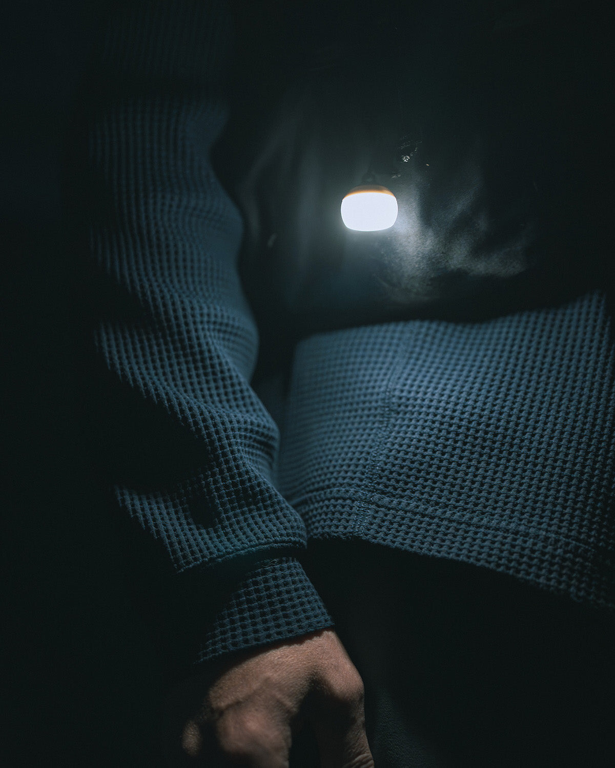 Micro Hozuki, clipped to a jacket and lit at night