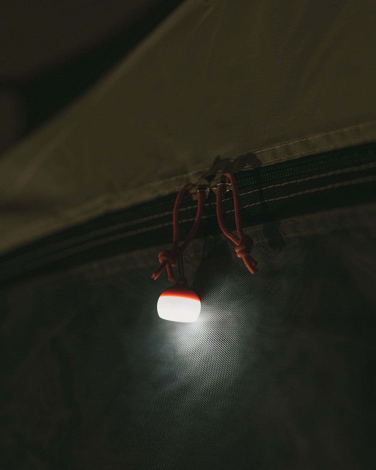 Micro Hozuki, hung from a tent zipper pull and lit