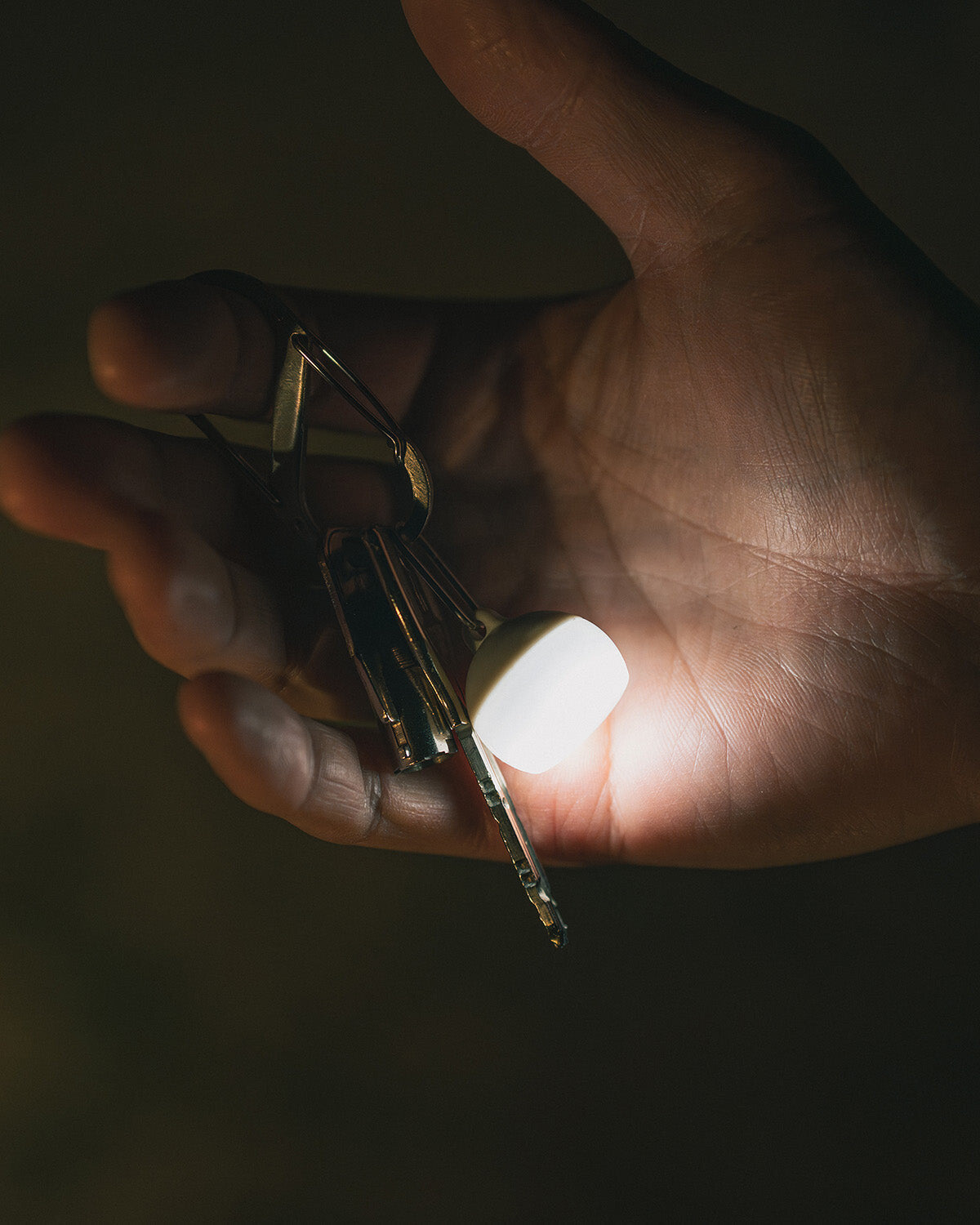 Micro Hozuki, attached to a key ring and lit in the hand