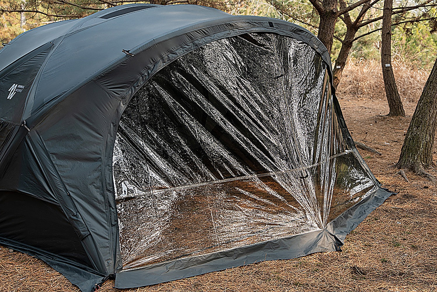 Three-quarter exterior view of the Minimal Works Shelter GM with the TPU door panel fitted to its arched front opening