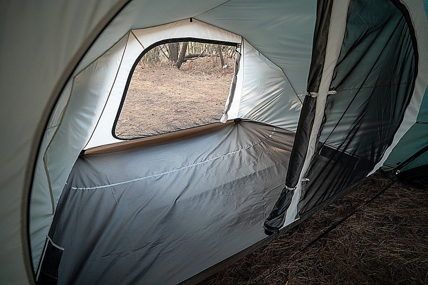 Close-up along the Vestibule Inner Tent's gray sidewall inside Shelter GM, window rolled open to the woods