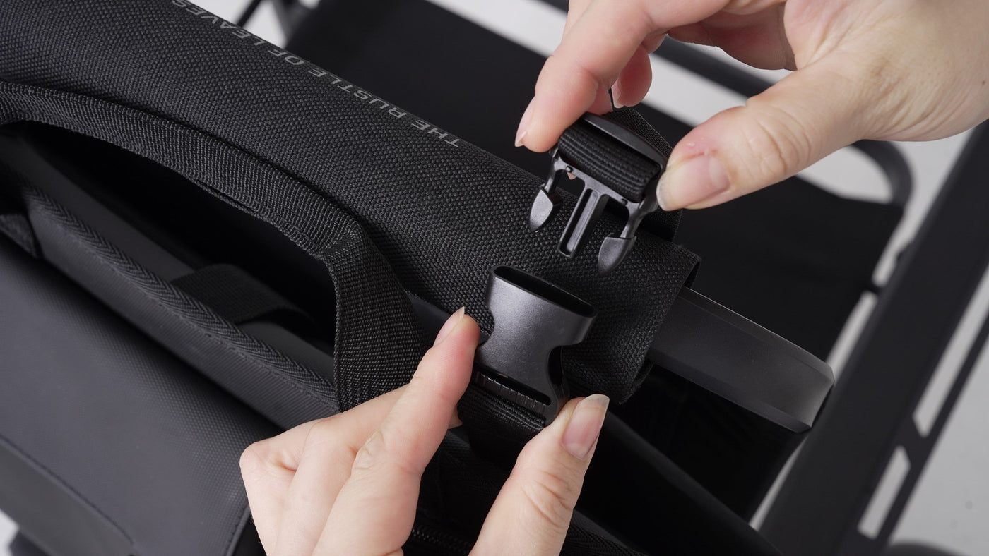 BUENOFE Multi Storage Bag Slim close-up of the side-release buckle and webbing strap being clicked together by hand, showing the mounting hardware that secures the bag to a chair back.