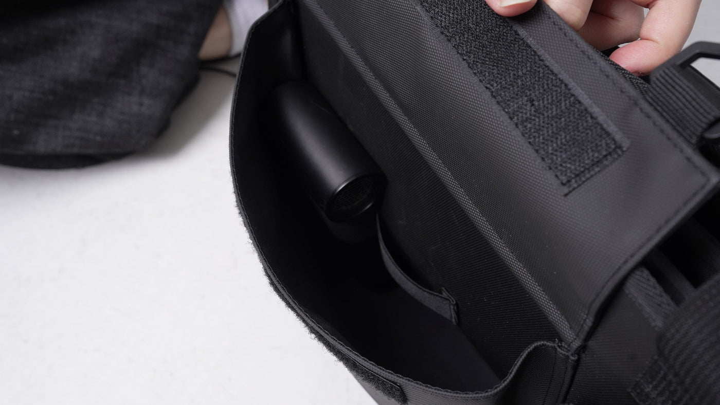 BUENOFE Multi Storage Bag Slim main compartment held open to show the padded interior and a cylindrical item stored inside, highlighting the roomy flat storage space and internal retention.