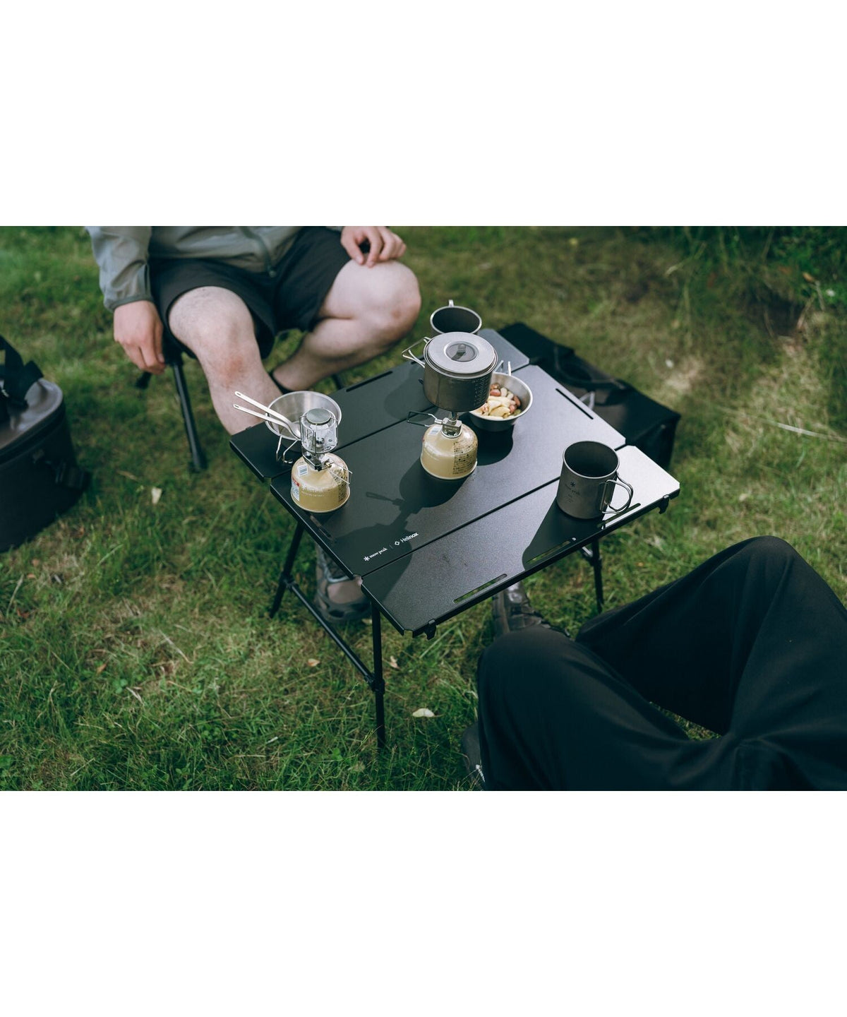 Noga Table, Black, a lantern and mugs on the aluminium top