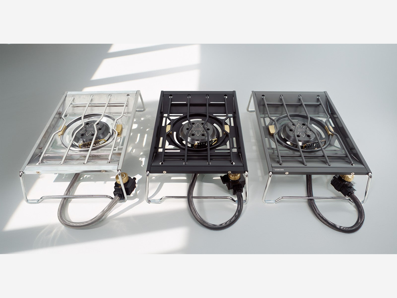 Personal Flat Burner in three colors — Silver, Black, and Titan — side by side