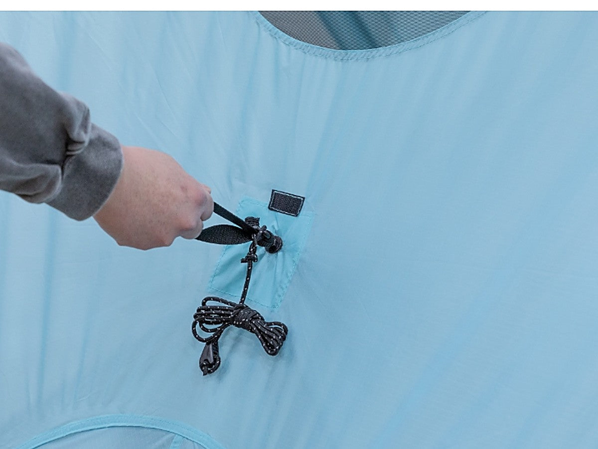 Hand pulling the one-action hub to deploy the tent