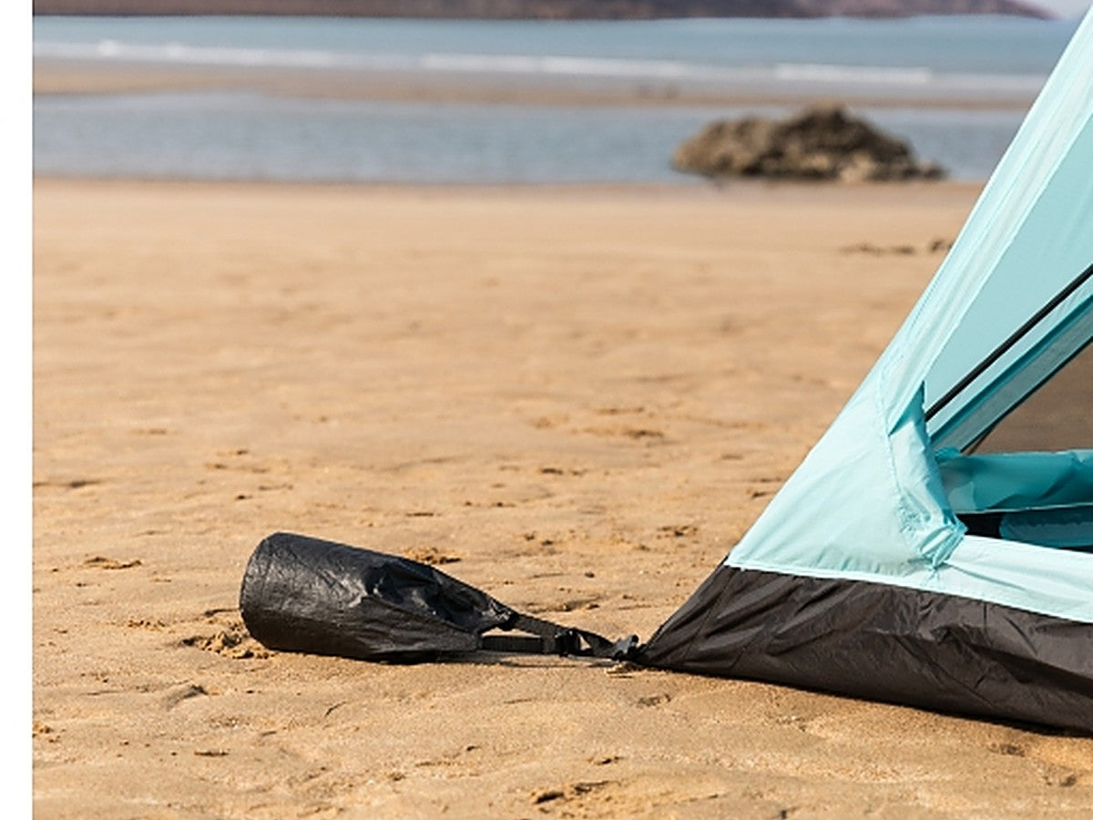 Sandbag anchoring the tent on a sandy beach