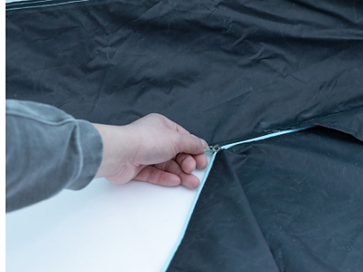 Hand unzipping the tent floor to open it