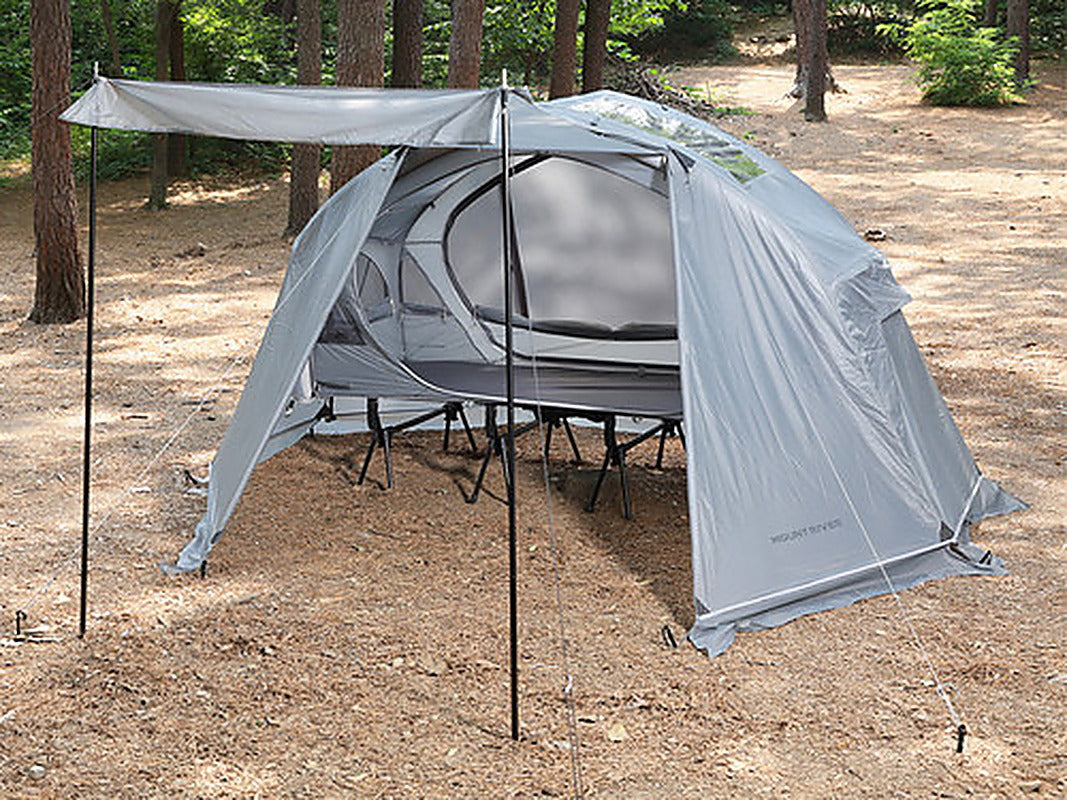 Grey Air rainfly door propped open as a canopy by two door poles in a forest (tent, rainfly and cot sold separately).