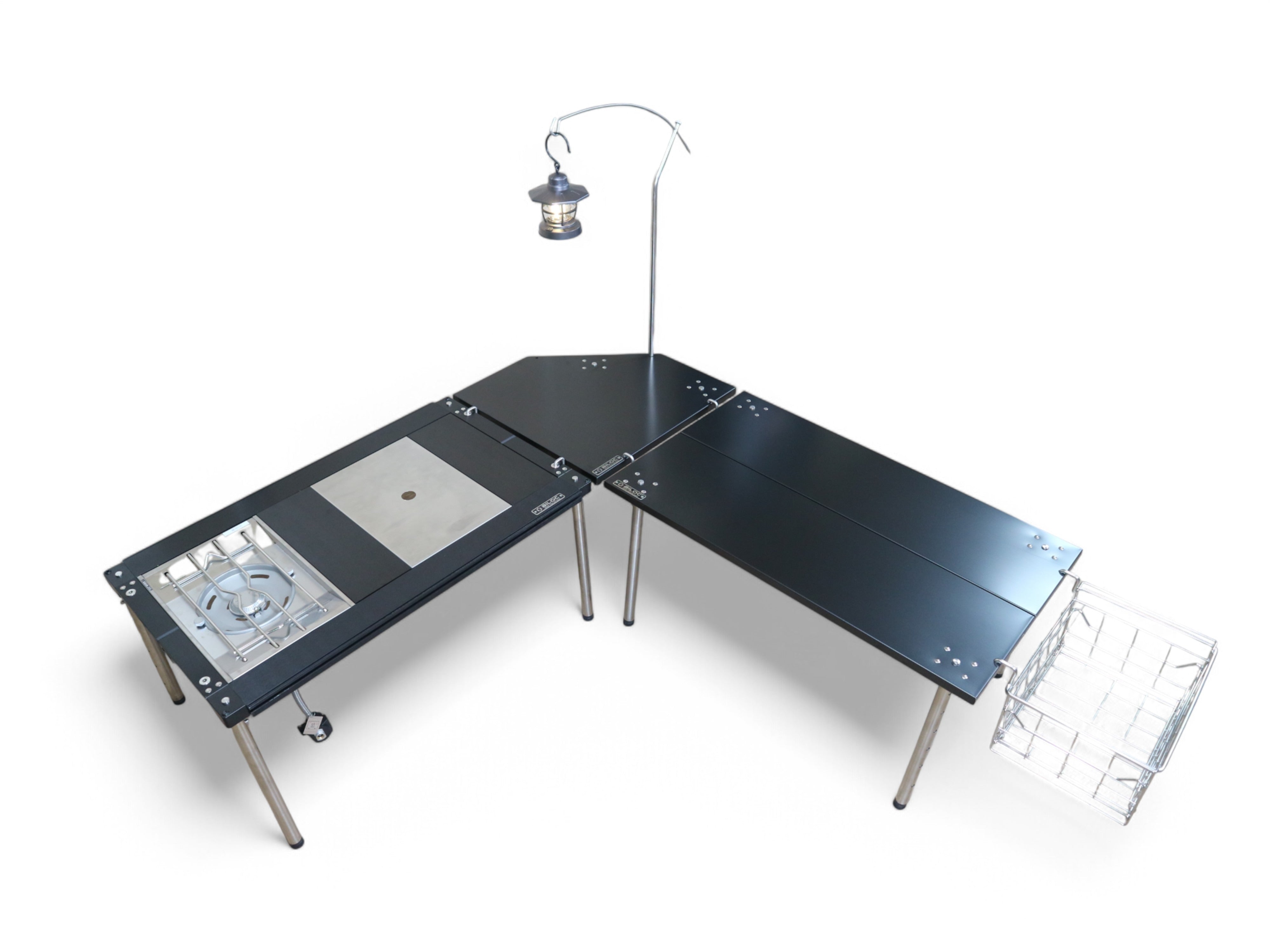 Black Ribera table in an L-shape camp kitchen with a lantern hanging from a mounted arm and a wire basket hung beneath the edge.