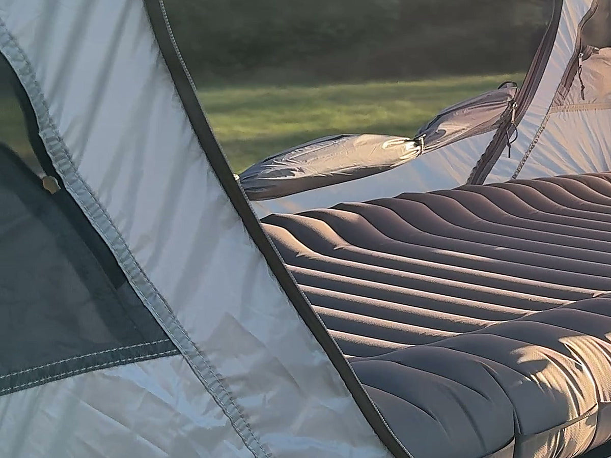 Sky Mat Wave 77 on a camp cot inside the Neo Nest 80 Air, wave cells in evening light (tent and cot sold separately).