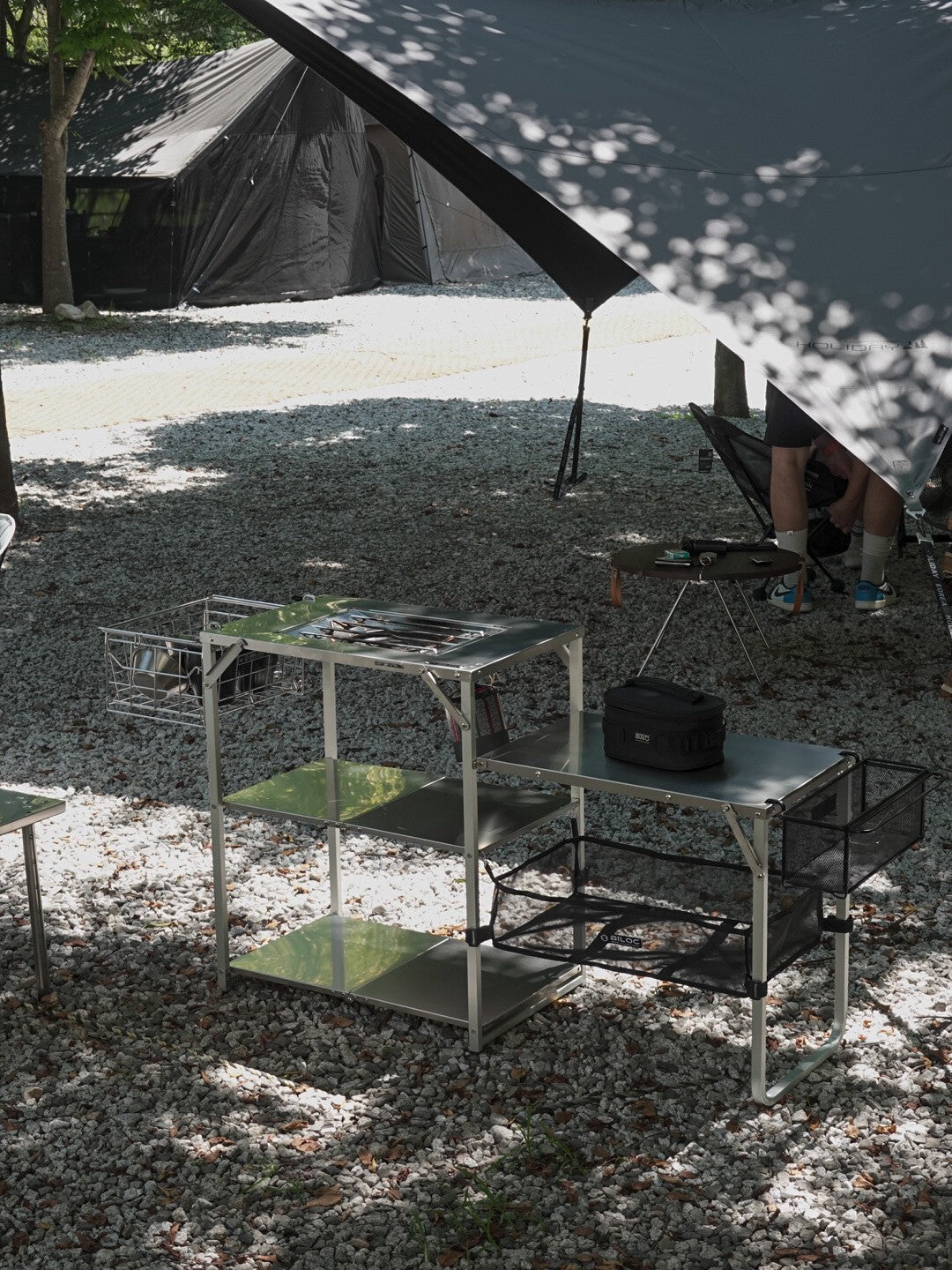 Biloc Stella shelf kitchen setup under a shade tarp at a gravel campsite