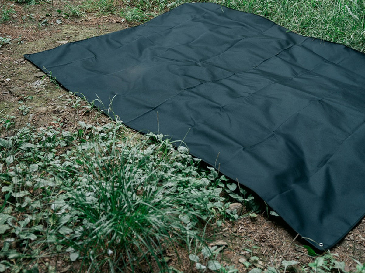 Black CORDURA Ground Sheet XXL laid flat on a forest floor