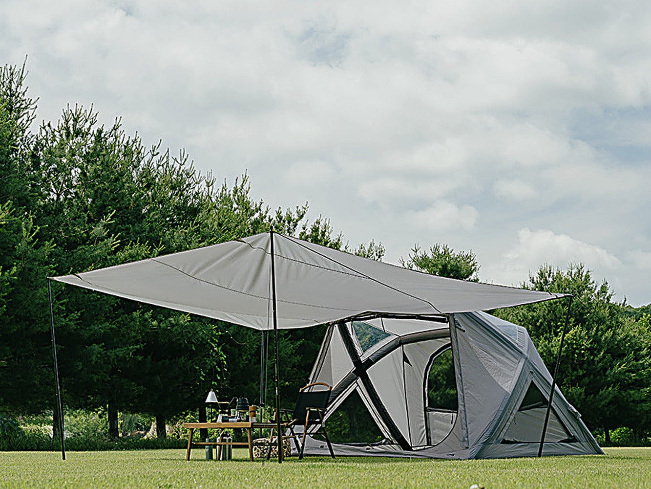 The the Earth Geo-Air 4 tent with the extension sun shade pitched over a table and chairs outdoors