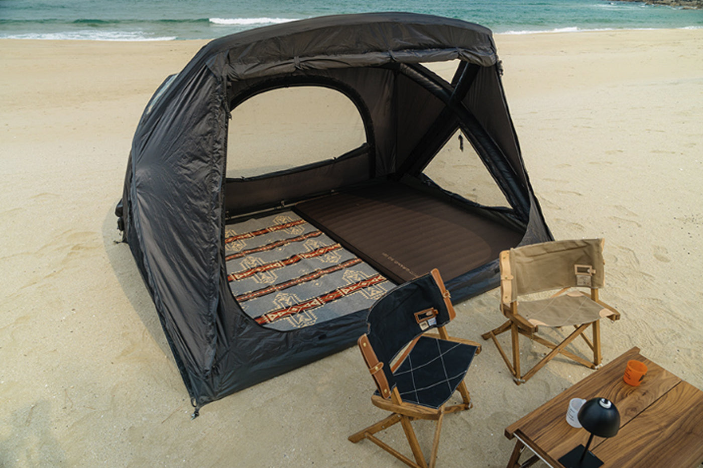 theEarth GEO AIR4 Tent, Black, interior with cot and chairs looking out to the campsite