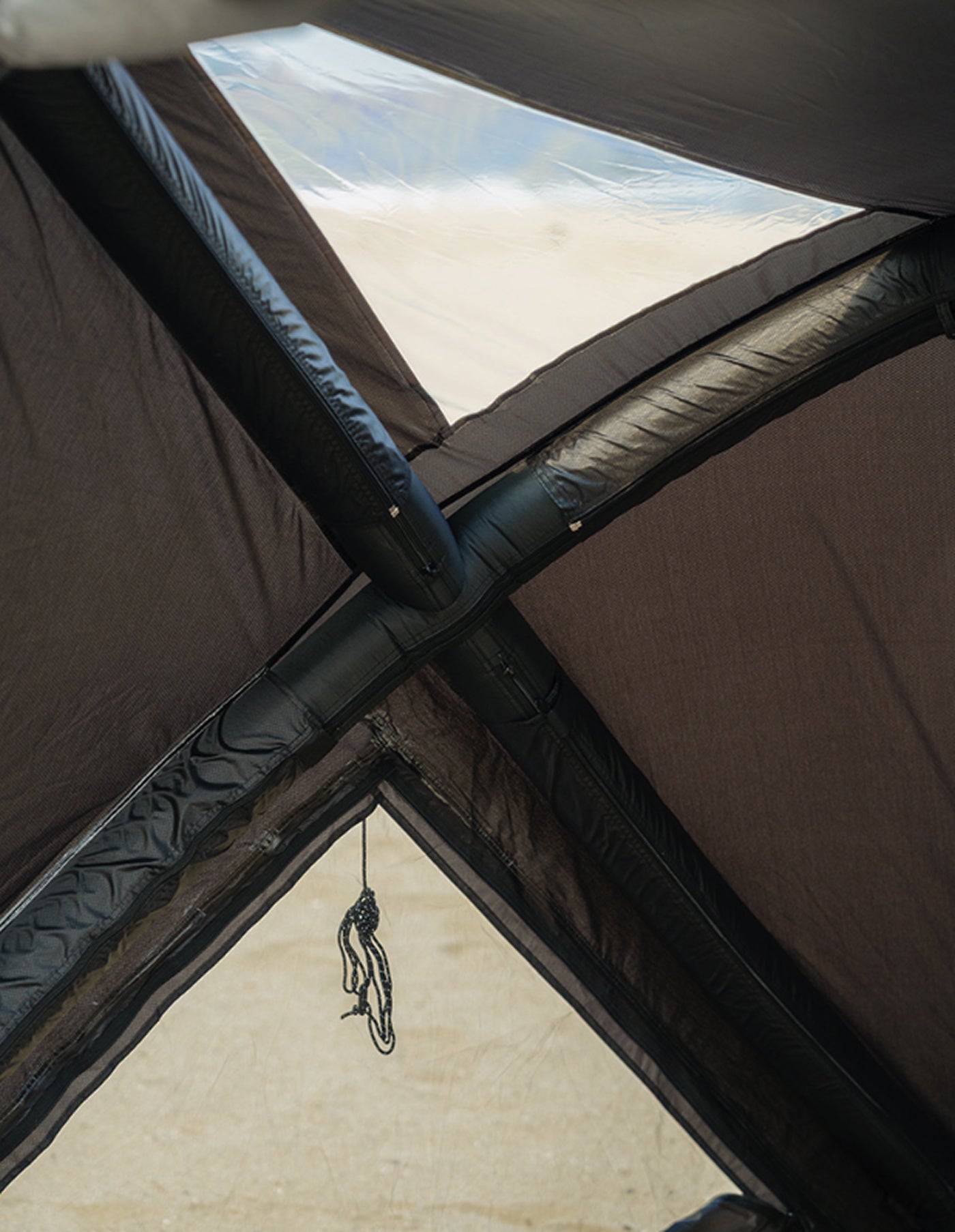 theEarth GEO AIR4 Tent, Black, interior X-frame window with daylight and beach beyond