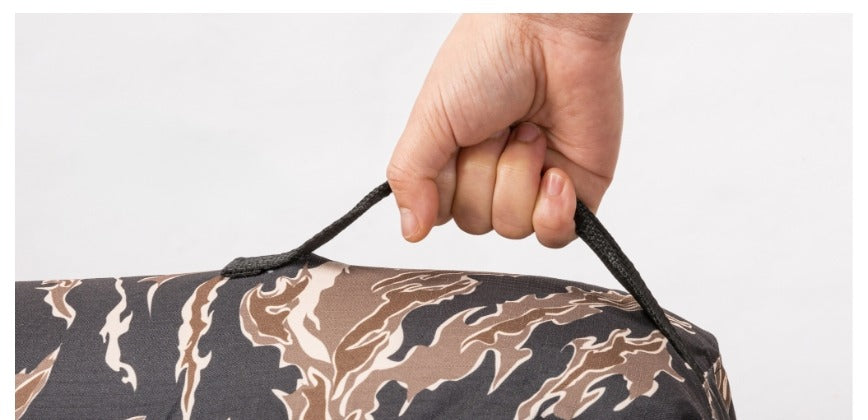Hand gripping one of the two top carry handles