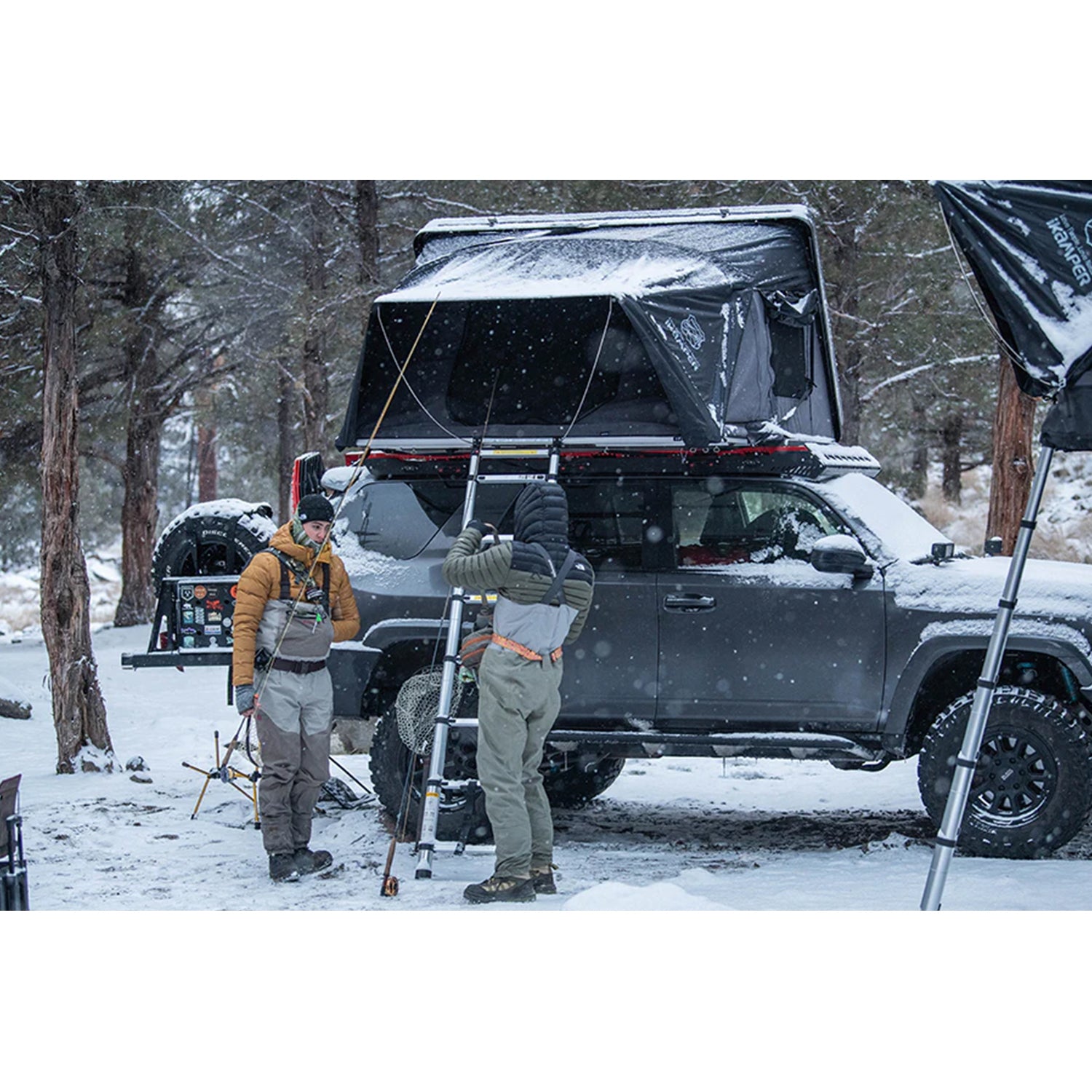 Two people with fully setup iKamper Skycamp3.0 in the snowy weather